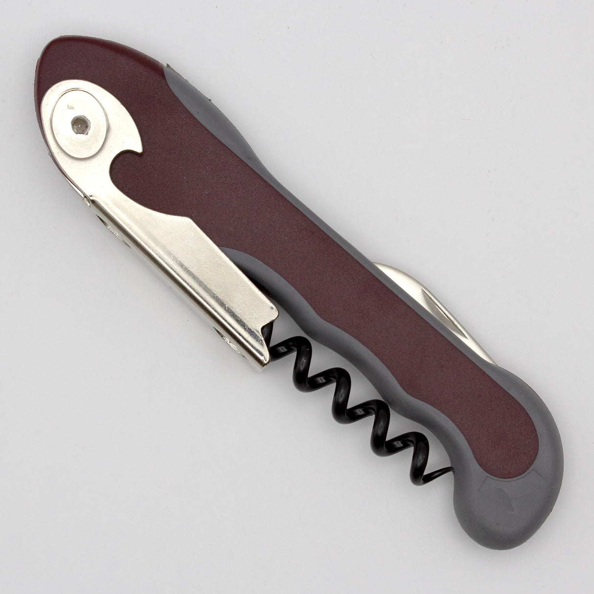 A closed Soft Touch 001 Single Lever Waiter's Friend Corkscrew by Soft Touch, featuring a maroon and gray handle and a visible metal spiral for opening wine bottles, rests on a plain light surface.