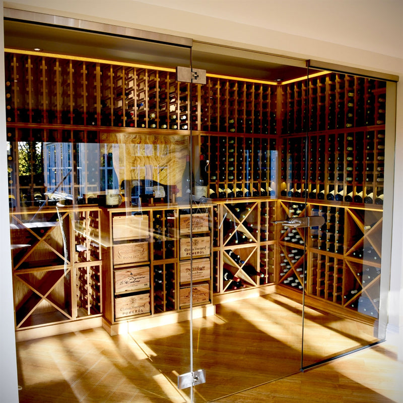 Modern wine room with wooden wine racking behind a set of glass doors.