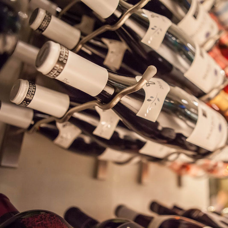 A zoomed in image of wine being stored on metal wine racking.