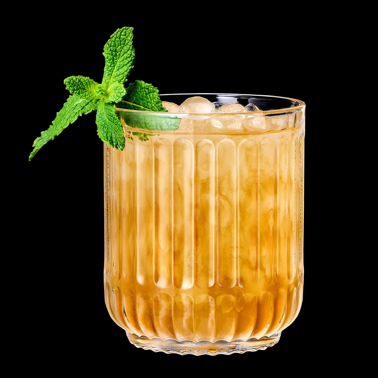 A glass of iced brown beverage garnished with a sprig of fresh mint, elegantly served in a lead-free crystal Riedel Restaurant Bar Rituals Double Rocks Tumbler (350ml), set against a striking black background.