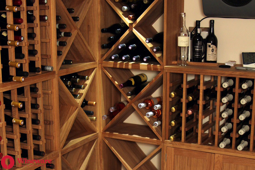 Wooden wine rack with various wine bottles in a home setting