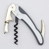 The Soft Touch 002 Double Lever Waiter's Friend Corkscrew by Soft Touch is a metal and plastic wine opener featuring a foldable double lever, integrated bottle opener, and small serrated knife, designed for efficiently opening wine bottles.