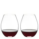 Two Riedel O Range Stemless Old World Syrah Glasses (Set of 2) by Riedel, each partially filled with red wine, are placed side by side against a plain white background. With their modern silhouette, these glasses are both elegant and fully dishwasher safe for convenient cleanup.