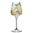 A Riedel Restaurant Grape Optical White Wine / Champagne / Spritz Glass (590ml) by Riedel, crafted from lead-free crystal, is filled with a sparkling beverage, ice cubes, two lime slices, and a sprig of mint, set against a white background.
