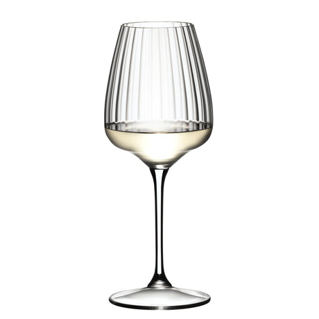 A Riedel Restaurant Grape Optical White Wine / Champagne / Spritz Glass (590ml) from Riedel, made from lead-free crystal and featuring vertical optical lines, is half-filled with white wine and stands against a plain white background.