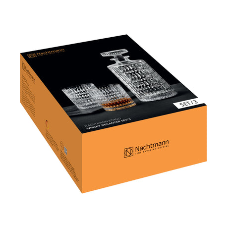 An orange and black box containing the Nachtmann Ethno Whisky Decanter & Two Glass Set by Nachtmann, with packaging that displays an image of a crystal decanter and two matching whisky tumblers crafted from premium crystal glass.