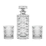 The Nachtmann Ethno Whisky Decanter & Two Glass Set by Nachtmann features an elegant crystal decanter with a stopper, accompanied by two matching whisky tumblers, all adorned with a sophisticated diamond-cut pattern.