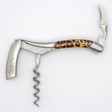 The Laguiole en Aubrac Sommelier Corkscrew features a leopard print handle, folded knife, and bottle opener—a stylish accessory from Laguiole en Aubrac shown on a white background.