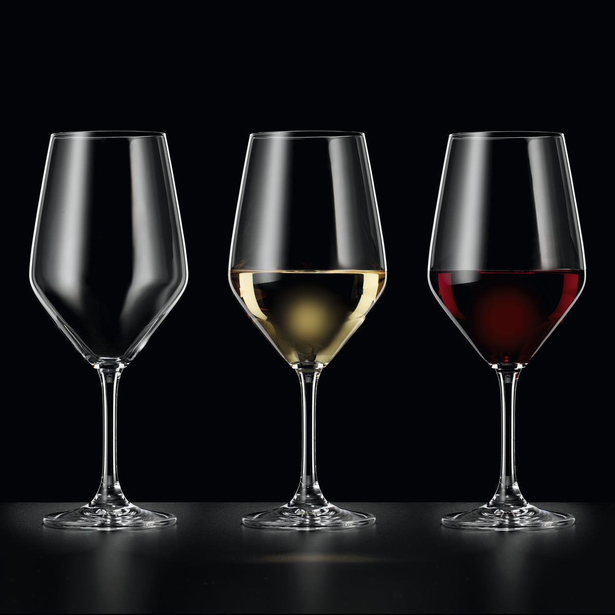 Three crystal wine glasses are lined up side by side: the left glass is empty, the middle contains white wine, and the right contains red wine. The sleek design of each Spiegelau Festino Universal Red & White Wine Glass from Spiegelau stands out against the black background, highlighting their elegance and durability. These glasses come in a set of 6 and are dishwasher safe for easy cleaning.