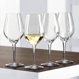 Four Spiegelau Restaurant Authentis Universal/White Wine Glasses (420ml, set of 12) are arranged on a wooden surface; three are empty and one holds white wine, with a bright minimalistic background showcasing Spiegelau elegance.