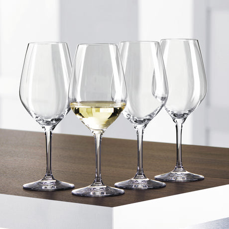 Twelve Spiegelau Restaurant Authentis Small White Wine Glasses by Spiegelau, each with a 360ml capacity, are arranged on a wooden and white surface; three glasses remain empty while one is filled with white wine, showcasing the professional crystal design's elegance and craftsmanship.