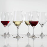 Six Spiegelau Expert Wine Tasting Glasses (260ml, set of 6) by Spiegelau are arranged in two neat rows; three glasses hold red or white wine while the other three remain empty. Each crystalline wine glass is displayed on a reflective surface with a plain white background, accentuating their clarity and elegance.
