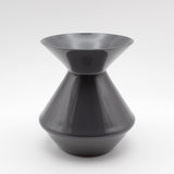 The Zalto Crystal Wine Tasting Spittoon - Dark Grey / Small by Zalto features a sleek, glossy finish with a wide flared top and bottom connected by a narrow center, shown against a plain white background.