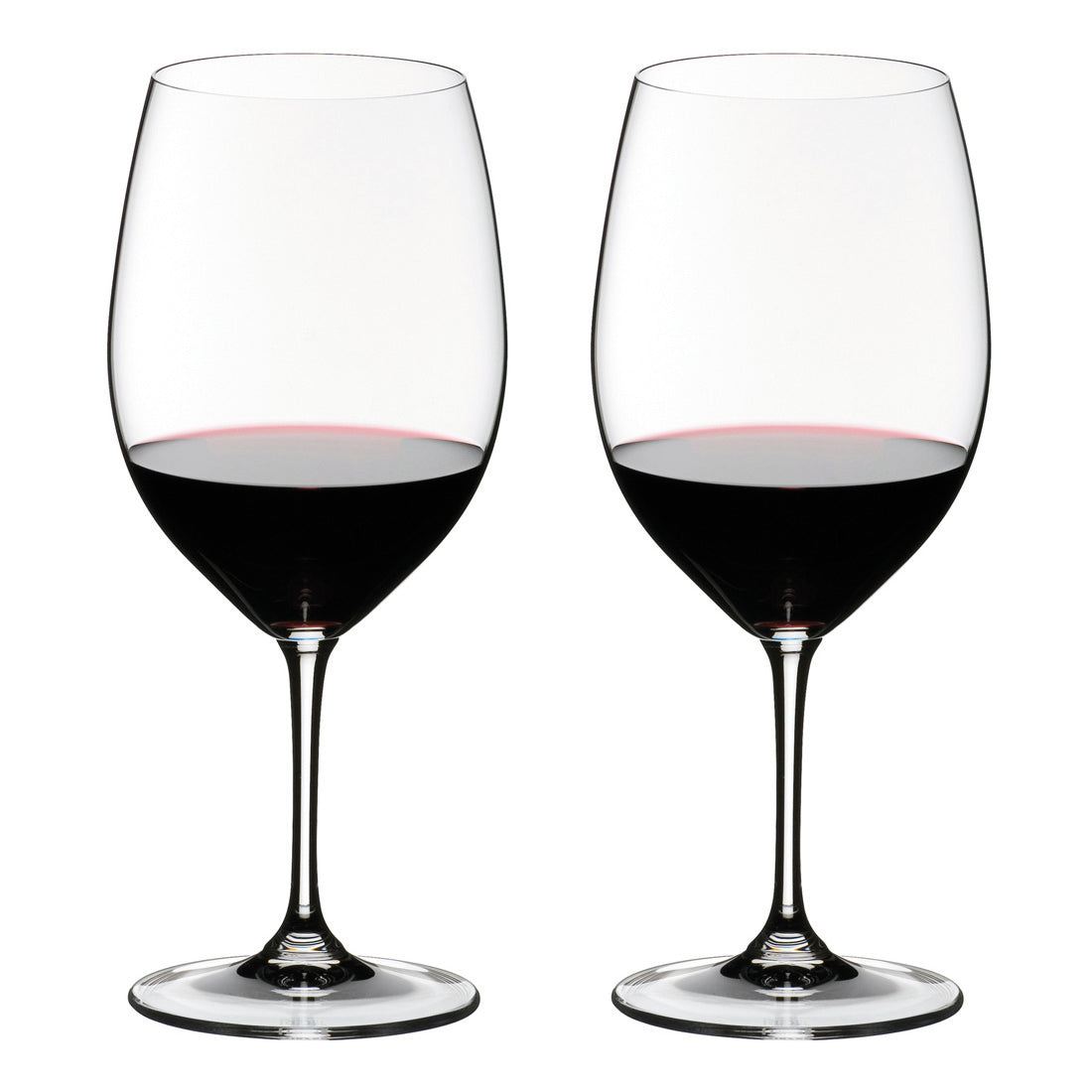Two wine glasses filled with red wine on a white background