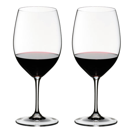 Two wine glasses filled with red wine on a white background