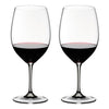 Two wine glasses filled with red wine on a white background
