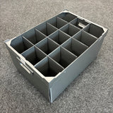 A Wineware USED - GREAT CONDITION Wine Glass Storage Box with 15 cells and measuring 240mm high is shown placed on a gray carpeted floor. Made of gray plastic, the box features handles and rectangular dividers that create a grid inside, making it ideal for use as a durable glassware or wine glass storage box.