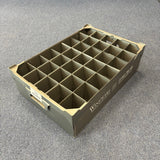The Wineware USED - GREAT CONDITION Wine Glass Storage Box (140mm High, 35 Cells) is a gray plastic organizer with square grid compartments and labels on the front and side, shown on a blue-gray carpeted floor.
