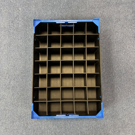 Top view of a USED - GREAT CONDITION Wineware Wine Glass Storage Box, 125mm high with 35 compartments and cardboard dividers, ideal for glassware storage, shown on a gray carpeted floor.