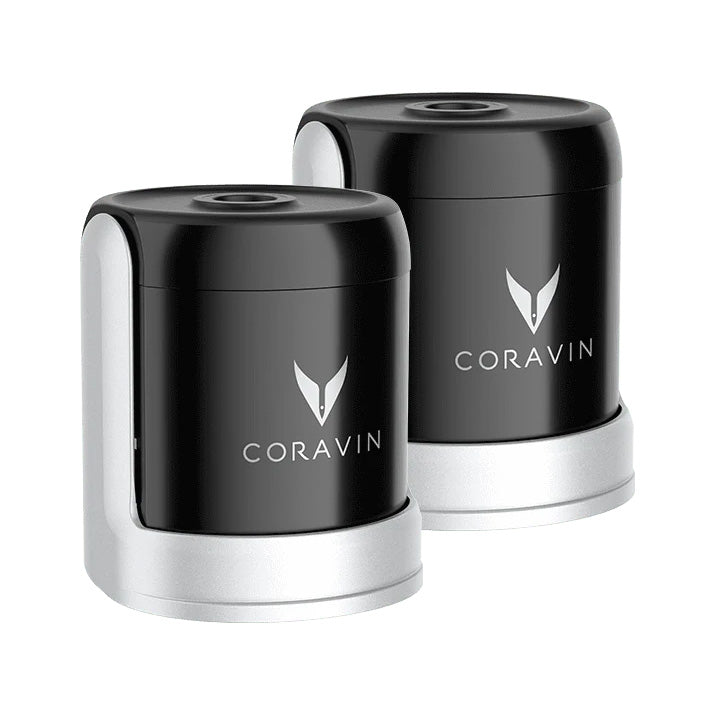 Two black and silver Coravin Sparkling Wine Stoppers from Coravin are displayed side by side, each featuring the brand’s logo on the front. The Coravin Sparkling Wine Stopper - Set of 2 is designed for use with the Sparkling Wine Preservation System to help keep your sparkling wine bottles fresh and bubbly for longer.