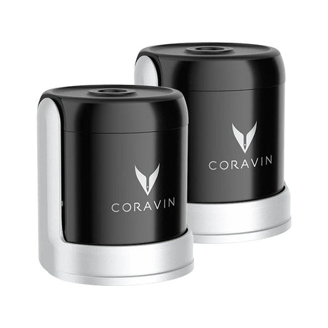 Two black and silver Coravin Sparkling Wine Stoppers from Coravin are displayed side by side, each featuring the brand’s logo on the front. The Coravin Sparkling Wine Stopper - Set of 2 is designed for use with the Sparkling Wine Preservation System to help keep your sparkling wine bottles fresh and bubbly for longer.