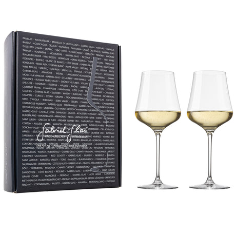 Two Gabriel-Glas StandArt Universal Red & White Wine Glasses filled with white wine are set beside a sleek black Gabriel-Glas box, which displays the outline of a universal wine glass, handwritten-style branding, and a backdrop of assorted wine names in bold white lettering.