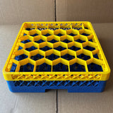 The USED - GREAT CONDITION Traex Rack Master Glass Washer Tray by Wineware (500x500x120mm, 30 glasses, 81mm cell) features a yellow honeycomb top and blue base, and is shown on a cardboard surface.