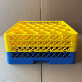 A stack of three yellow and one blue Wineware Traex Rack Master Glass Washer Trays (USED - GREAT CONDITION, 500 x 500 x 200mm, holds 30 glasses, 81mm cell) sits on a cardboard surface with a cardboard background.