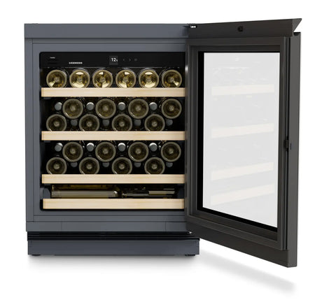 The Liebherr Vinidor UWgb 3631 Undercounter Wine Cabinet stores up to 44 bottles on wooden racks behind a glass door, featuring a top digital temperature display for optimal preservation.