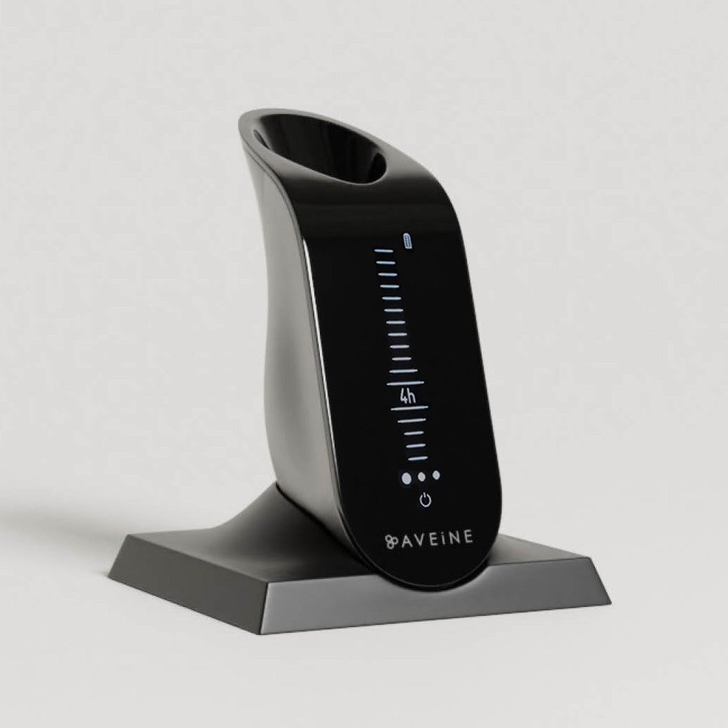 The Aveine Original Smart Wine Aerator – Instant 1–24 Hour Aeration by Aveine, featuring a digital display with vertical measurement lines and a power button, is elegantly displayed on its matching black stand against a plain background.