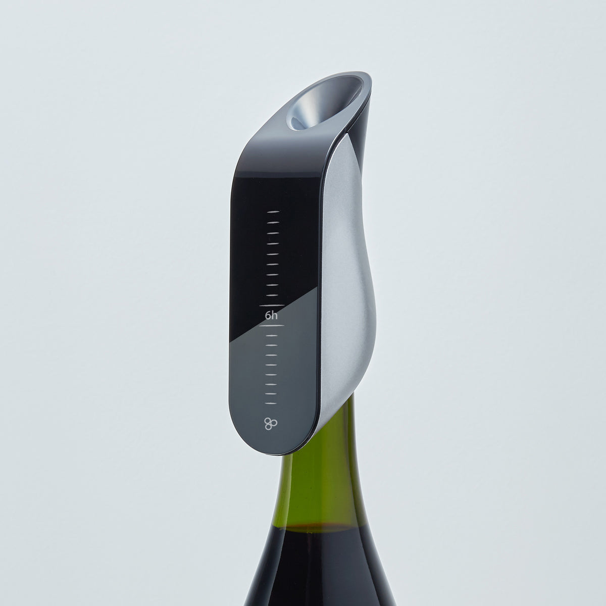 The Aveine Original Smart Wine Aerator by Aveine, featuring measurement markings and offering instant 1–24 hour precise aeration, is attached to the top of a green wine bottle against a plain white background, enhancing the tasting experience with modern, sleek design.