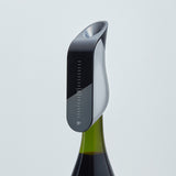 The Aveine Original Smart Wine Aerator by Aveine, featuring measurement markings and offering instant 1–24 hour precise aeration, is attached to the top of a green wine bottle against a plain white background, enhancing the tasting experience with modern, sleek design.